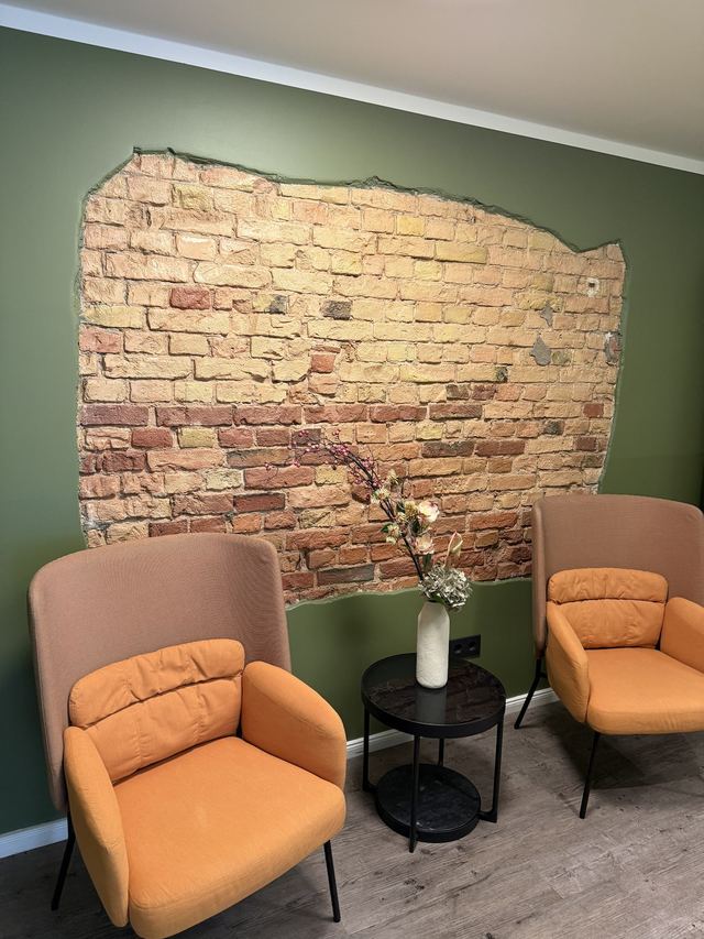 Lounge-Ecke mit Sesseln vor Backsteinwand im Fantastic Apartment