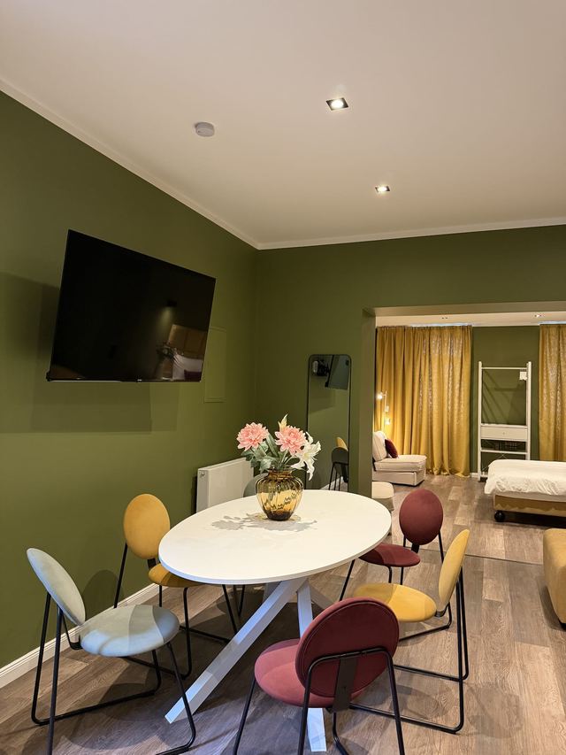 Living area with round dining table and corner sofa in the Prestige Suites