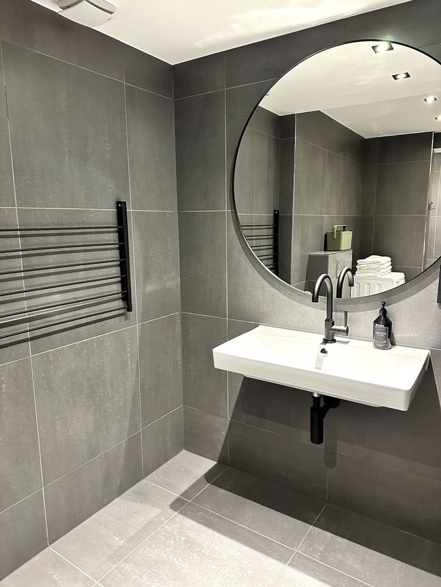 Badezimmer mit Waschbecken und Spiegel in den Prestige Suites by P&M